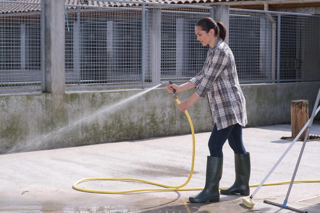 woman cleaning outdoor kennel area